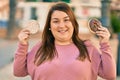 Young hispanic plus size woman smiling happy holding rice cake and donut at the city Royalty Free Stock Photo