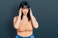 Young hispanic plus size woman wearing casual clothes with hand on head for pain in head because stress