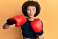 Young hispanic sporty girl using boxing gloves looking at the camera blowing a kiss being lovely and sexy Royalty Free Stock Photo