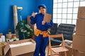 Young hispanic technician working at house renovation smiling happy and positive, thumb up doing excellent and approval sign Royalty Free Stock Photo