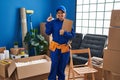 Young hispanic technician working at house renovation smiling with an idea or question pointing finger with happy face, number one Royalty Free Stock Photo