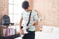 Young hispanic teenager musician playing electrical guitar at bedroom Royalty Free Stock Photo