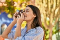 Young hispanic tourist girl smiling happy using camera at the park Royalty Free Stock Photo