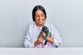Young hispanic veterinary girl examining cat using stethoscope at the clinic