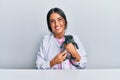 Young hispanic veterinary girl examining cat using stethoscope at the clinic