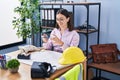 Young hispanic woman architect make photo by the smartphone to plans at office Royalty Free Stock Photo