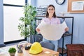 Young hispanic woman architect reading blueprints at office Royalty Free Stock Photo