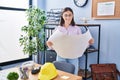 Young hispanic woman architect reading blueprints at office Royalty Free Stock Photo