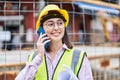 Young hispanic woman architect talking on the smartphone holding blueprints at street Royalty Free Stock Photo