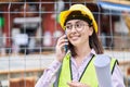 Young hispanic woman architect talking on the smartphone holding blueprints at street Royalty Free Stock Photo