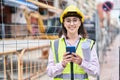 Young hispanic woman architect using smartphone holding blueprints at street Royalty Free Stock Photo