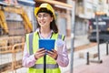 Young hispanic woman architect using touchpad holding blueprints at street Royalty Free Stock Photo