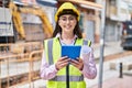 Young hispanic woman architect using touchpad holding blueprints at street Royalty Free Stock Photo