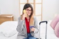 Young hispanic woman business worker talking on the smartphone holding credit card at hotel room Royalty Free Stock Photo