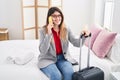 Young hispanic woman business worker talking on the smartphone sitting on bed at hotel room Royalty Free Stock Photo