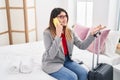 Young hispanic woman business worker talking on the smartphone sitting on bed at hotel room Royalty Free Stock Photo