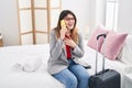 Young hispanic woman business worker talking on the smartphone sitting on bed at hotel room Royalty Free Stock Photo