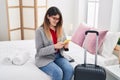 Young hispanic woman business worker using smartphone sitting on bed at hotel room Royalty Free Stock Photo