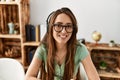 Young hispanic woman call center agent smiling confident sitting on table at home Royalty Free Stock Photo