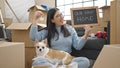 Young hispanic woman with chihuahua dog smiling confident holding blackboard and keys at new home Royalty Free Stock Photo