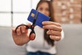 Young hispanic woman cutting credit card at home Royalty Free Stock Photo