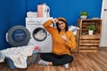 Young hispanic woman doing laundry smiling making frame with hands and fingers with happy face Royalty Free Stock Photo