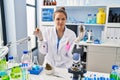 Young hispanic woman doing weed oil extraction at laboratory relaxed with serious expression on face