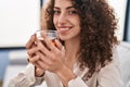 Young hispanic woman drinking tea sitting on sofa at home Royalty Free Stock Photo