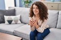 Young hispanic woman drinking tea sitting on sofa at home Royalty Free Stock Photo