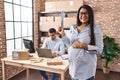 Young hispanic woman expecting a baby working at small business ecommerce smiling happy pointing with hand and finger to the side Royalty Free Stock Photo