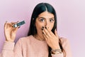 Young hispanic woman holding computer memory covering mouth with hand, shocked and afraid for mistake Royalty Free Stock Photo