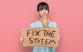 Young hispanic woman holding fix the system banner cardboard covering mouth with hand, shocked and afraid for mistake Royalty Free Stock Photo