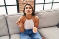 Young hispanic woman holding pills and cbd oil looking at the camera blowing a kiss being lovely and sexy Royalty Free Stock Photo