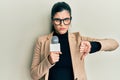 Young hispanic woman holding reporter microphone with angry face, negative sign showing dislike with thumbs down, rejection Royalty Free Stock Photo