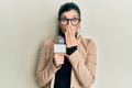 Young hispanic woman holding reporter microphone covering mouth with hand, shocked and afraid for mistake Royalty Free Stock Photo