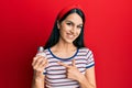 Young hispanic woman holding salt shaker smiling happy pointing with hand and finger Royalty Free Stock Photo