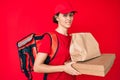 Young hispanic woman holding take away paper bag clueless and confused expression Royalty Free Stock Photo