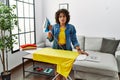 Young hispanic woman ironing clothes at home looking sleepy and tired, exhausted for fatigue and hangover, lazy eyes in the Royalty Free Stock Photo
