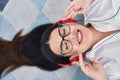 Young hispanic woman listening to music lying on floor at home Royalty Free Stock Photo