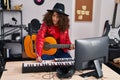 Young hispanic woman musician composing song playing classical guitar at music studio Royalty Free Stock Photo