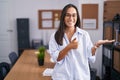 Young hispanic woman at the office showing palm hand and doing ok gesture with thumbs up, smiling happy and cheerful Royalty Free Stock Photo