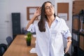 Young hispanic woman at the office stretching back, tired and relaxed, sleepy and yawning for early morning Royalty Free Stock Photo