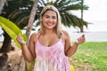 Young hispanic woman outdoors by the park screaming proud, celebrating victory and success very excited with raised arm Royalty Free Stock Photo