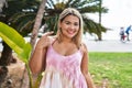 Young hispanic woman outdoors by the park smiling happy pointing with hand and finger Royalty Free Stock Photo