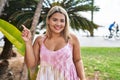 Young hispanic woman outdoors by the park smiling happy pointing with hand and finger to the side Royalty Free Stock Photo