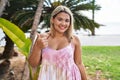 Young hispanic woman outdoors by the park smiling happy and positive, thumb up doing excellent and approval sign Royalty Free Stock Photo