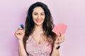 Young hispanic woman playing poker holding casino chips and cards smiling with a happy and cool smile on face Royalty Free Stock Photo