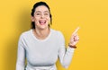 Young hispanic woman pointing with fingers to the side smiling and laughing hard out loud because funny crazy joke Royalty Free Stock Photo