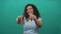 Young hispanic woman points finger to camera in studio setting; confidence motivation empowerment assertion Royalty Free Stock Photo