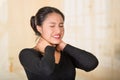 Young hispanic woman posing for camera showing signs of neck pain, holding hands on painful body part, injury concept Royalty Free Stock Photo